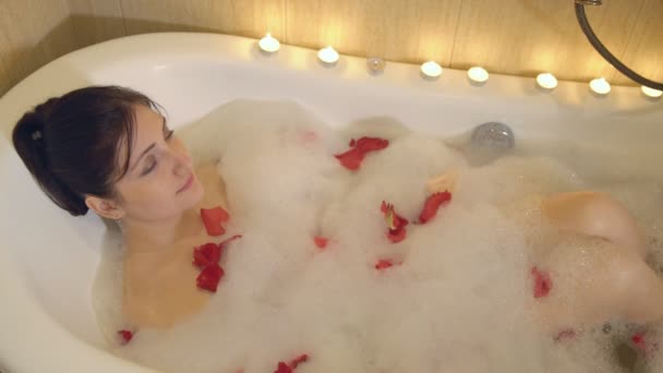 Блондинка в ванной с лепестками роз